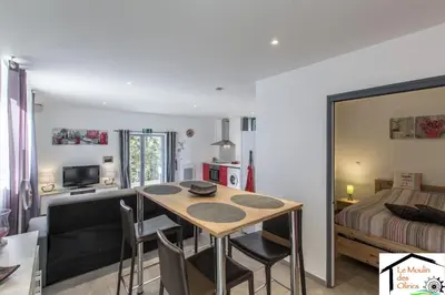 a living room with a dining room table and a bed at Le Moulin des Olirics in Sallanches