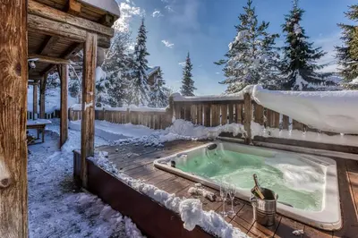 a hot tub in the snow on a deck at Chalet Persan in Megève
