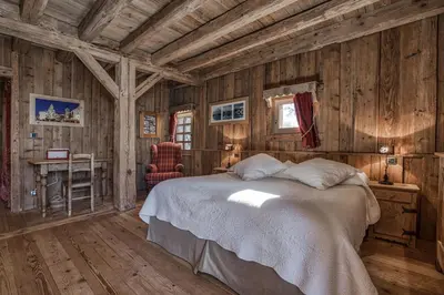a bedroom with wooden walls and a bed in a room at Chalet Persan in Megève