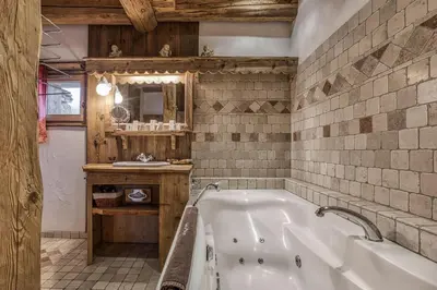a large bathroom with a tub and a sink at Chalet Persan in Megève