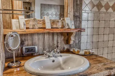 a bathroom counter with a sink and a mirror at Chalet Persan in Megève