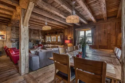 a dining room and living room with a table and chairs at Chalet Persan in Megève