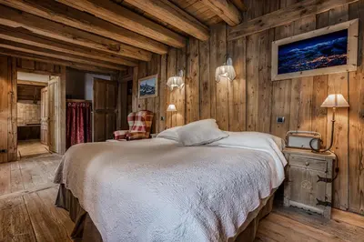 a bedroom with a bed in a wooden wall at Chalet Persan in Megève