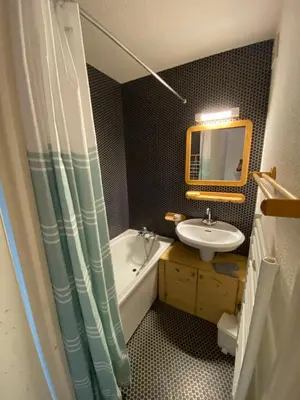a bathroom with a sink and a tub and a mirror at Amethyste in Saint-Gervais-les-Bains