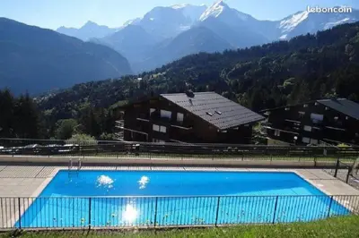 a large swimming pool with mountains in the background at Amethyste in Saint-Gervais-les-Bains