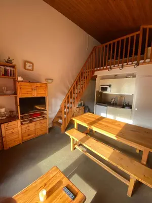 a room with a wooden table and a staircase at Amethyste in Saint-Gervais-les-Bains