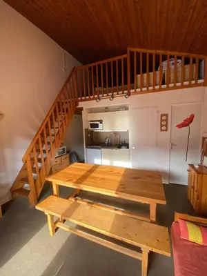 a room with a wooden table and a staircase at Amethyste in Saint-Gervais-les-Bains