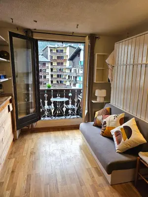 a living room with a couch and a large window at Cozy Chamonix Ski Studio with Mountain Views in Chamonix-Mont-Blanc