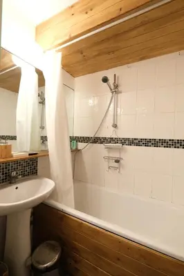 a bathroom with a bath tub and a sink at Cozy Chamonix Ski Studio with Mountain Views in Chamonix-Mont-Blanc