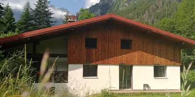 a brown and white barn with a red roof at Gîte Montvauthier in Les Houches