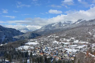 a small town in a valley with snow covered mountains at Gîte Montvauthier in Les Houches