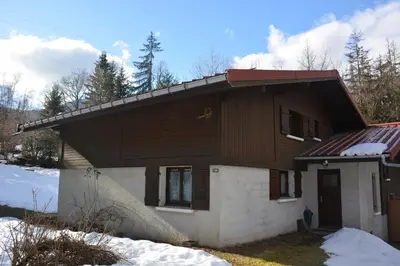 a house with snow in front of it at Gîte Montvauthier in Les Houches