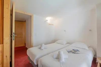 a bedroom with two beds with white sheets at Résidence Grand Roc - Bruyères 207 - Happy Rentals in Chamonix-Mont-Blanc