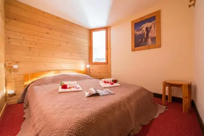 a bedroom with a bed with two towels on it at Résidence Grand Roc - Bruyères 207 - Happy Rentals in Chamonix-Mont-Blanc