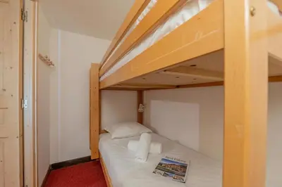 a bunk bed in a small room with white sheets at Résidence Grand Roc - Bruyères 207 - Happy Rentals in Chamonix-Mont-Blanc