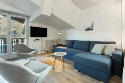 a living room with a blue couch and a chair at Residence du Brevent in Chamonix-Mont-Blanc