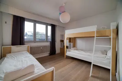 a bedroom with two bunk beds and a window at Residence du Brevent in Chamonix-Mont-Blanc