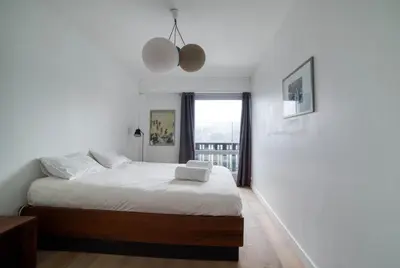 a white bedroom with a bed and a window at Residence du Brevent in Chamonix-Mont-Blanc