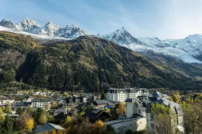 a city with snow capped mountains in the background at Residence du Brevent in Chamonix-Mont-Blanc