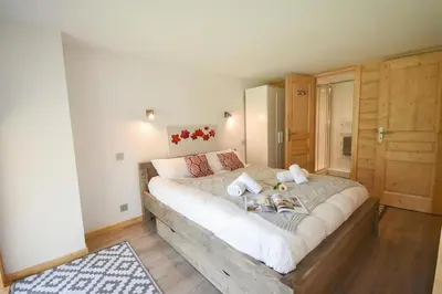 a bedroom with a large bed with two shoes on it at Résidence Grand Roc - Campanules 308 - Happy Rentals in Chamonix-Mont-Blanc