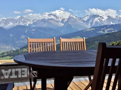 a table with two chairs and a view of mountains at Le Refuge in Cordon