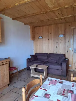 a living room with a couch and a table at Le Refuge in Cordon