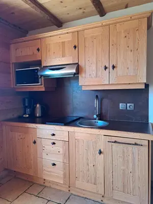 a kitchen with wooden cabinets and a sink at Le Refuge in Cordon