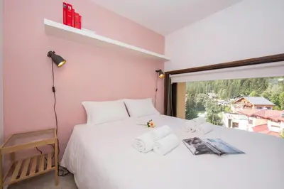 a kitchen with white cabinets and red walls at Résidence Grand Roc - Campanules 303 - Happy Rentals in Chamonix-Mont-Blanc