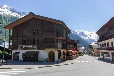 a building on the side of a street with mountains at Résidence Grands Montets 110 - Happy Rentals in Chamonix-Mont-Blanc