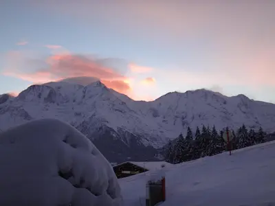 a snow covered mountain with a sunset in the background at Chalet Gabriel in Saint-Gervais-les-Bains