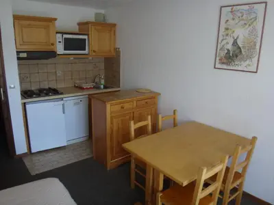 a small kitchen with a table and a stove and a microwave at Chalet Gabriel in Saint-Gervais-les-Bains