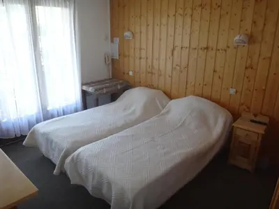 a bedroom with two beds and a wooden wall at Chalet Gabriel in Saint-Gervais-les-Bains