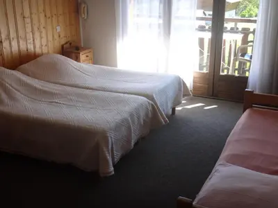 a hotel room with two beds and a sliding glass door at Chalet Gabriel in Saint-Gervais-les-Bains