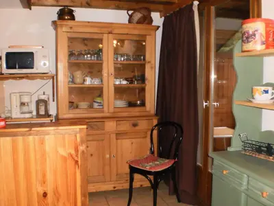 a kitchen with a wooden hutch and a chair at Location Montagne in Les Contamines-Montjoie