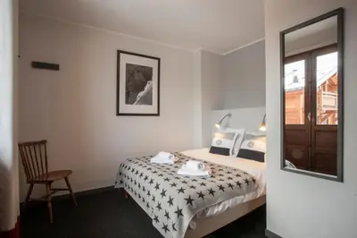 a hotel room with a bed and a chair at La Chaumière Mountain Lodge in Chamonix-Mont-Blanc