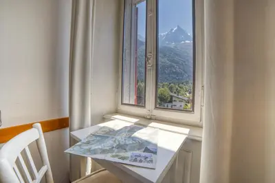 a table and a window with a view of a mountain at La Chaumière Mountain Lodge in Chamonix-Mont-Blanc