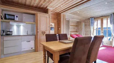 a kitchen and dining room with a wooden table and chairs at Hôtel Le Labrador in Chamonix-Mont-Blanc