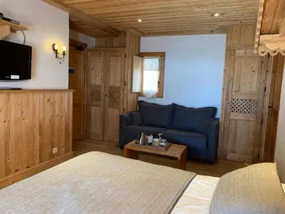 a living room with a blue couch and a table at Hôtel Le Labrador in Chamonix-Mont-Blanc