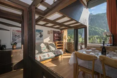 a kitchen and dining room with a table and a television at Résidence Grand Roc - Campanules 415 - Happy Rentals in Chamonix-Mont-Blanc