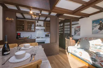 a kitchen and living room with a table and a couch at Résidence Grand Roc - Campanules 415 - Happy Rentals in Chamonix-Mont-Blanc