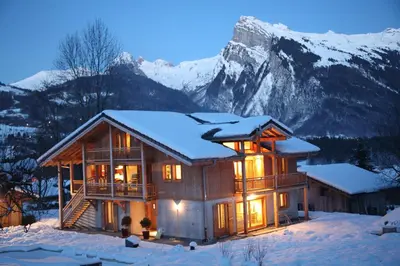a log cabin in the snow with a mountain at Chalet Brio in Samoëns