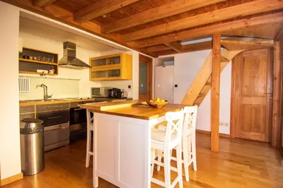 a kitchen with a white island and wooden ceilings at Chalet Brio in Samoëns