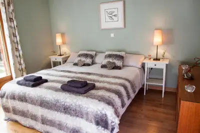 a bedroom with a large bed with two night stands at La Terrasse - 3 bedrooms with private Hot Tub in Samoëns