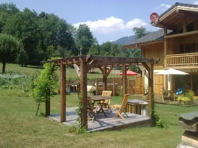a wooden gazebo in the yard of a house at La Terrasse - 3 bedrooms with private Hot Tub in Samoëns