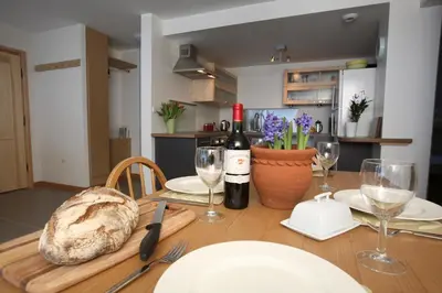 a table with a bottle of wine and a loaf of bread at La Terrasse - 3 bedrooms with private Hot Tub in Samoëns