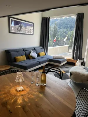 a living room with a blue couch and a table at Flaine Forum H1 Cassiopée Mezzanine & Terrasse in Flaine