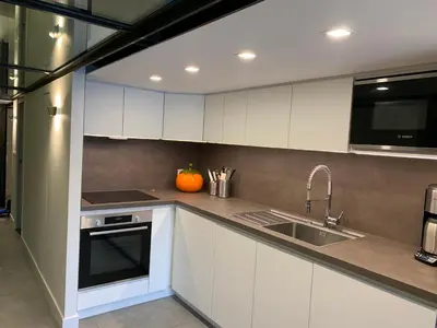 a kitchen with white cabinets and a sink at Flaine Forum H1 Cassiopée Mezzanine & Terrasse in Flaine
