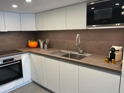 a kitchen with white cabinets and a sink at Flaine Forum H1 Cassiopée Mezzanine & Terrasse in Flaine