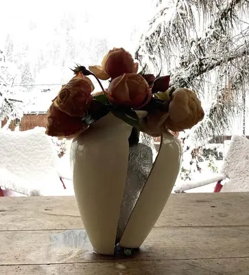 a white vase with a bouquet of flowers in it at Casa Mia in Saint-Gervais-les-Bains