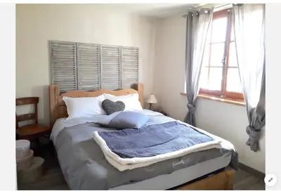 a bedroom with a bed with blue blankets and a window at Casa Mia in Saint-Gervais-les-Bains